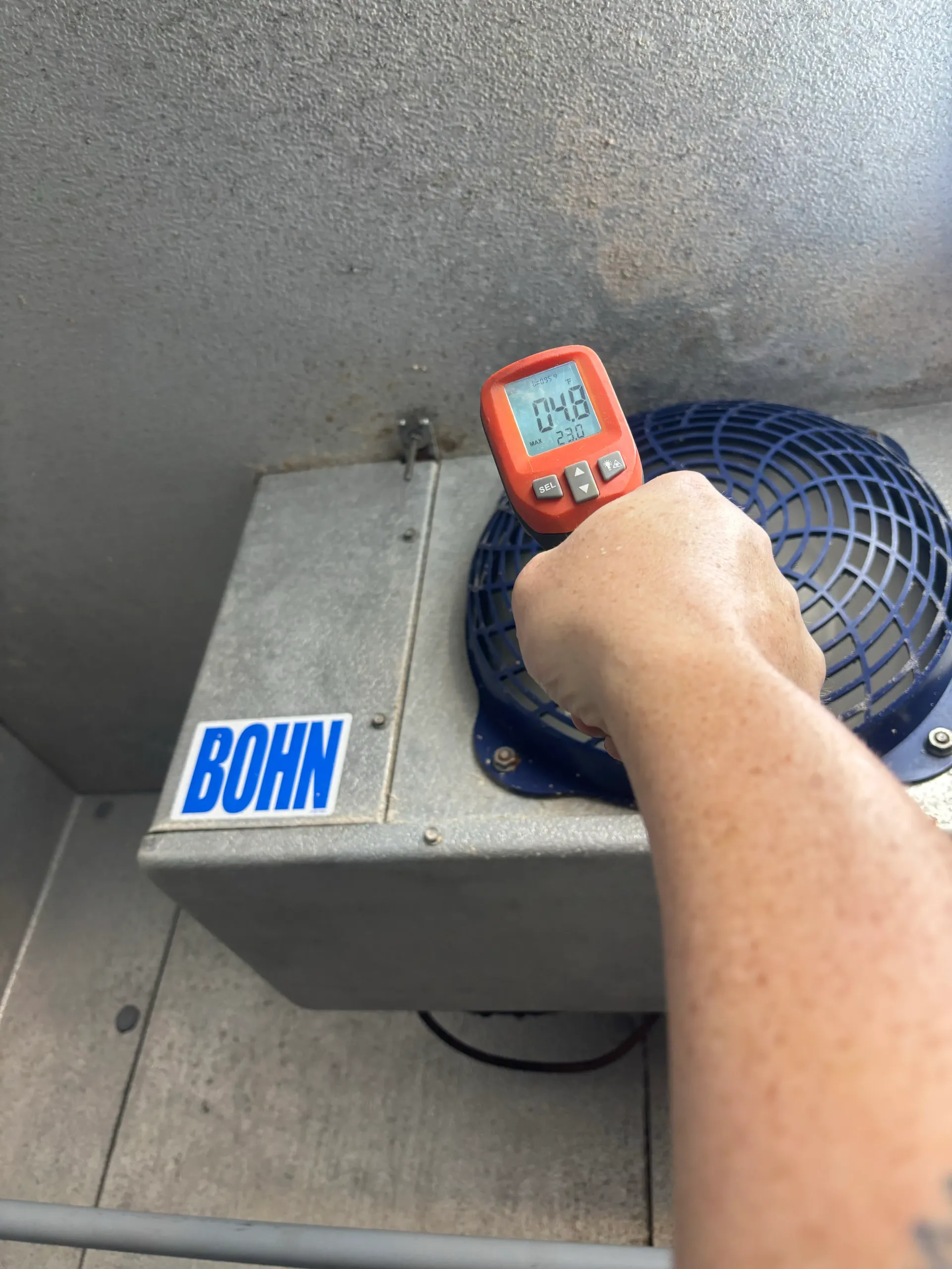 Second Bohn walk-in evaporator being checked with a digital thermometer