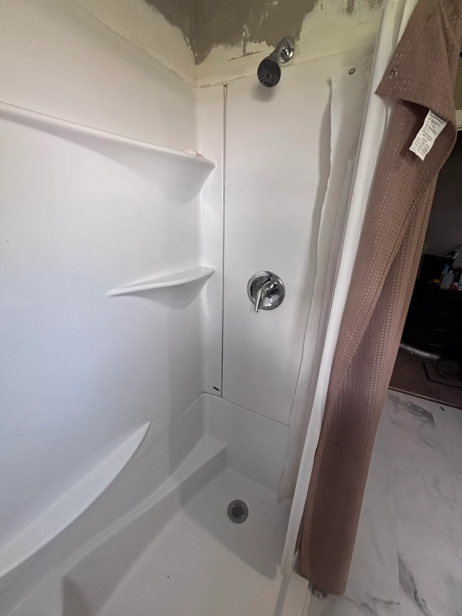 New shower valve and showerhead installed in a bathroom surround